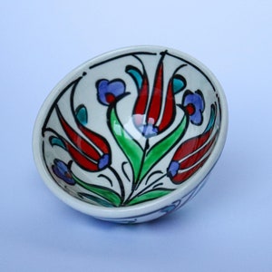 Könnte beinhalten: Eine kleine weiße Keramikschüssel mit handbemaltem Design aus roten, blauen und grünen Tulpen.