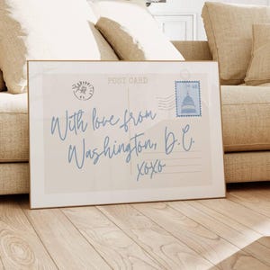 May include: Framed postcard print with the text "With love from Washington, D.C. xoxo" in light blue script. The print features a postage stamp with the Capitol building and a postmark.