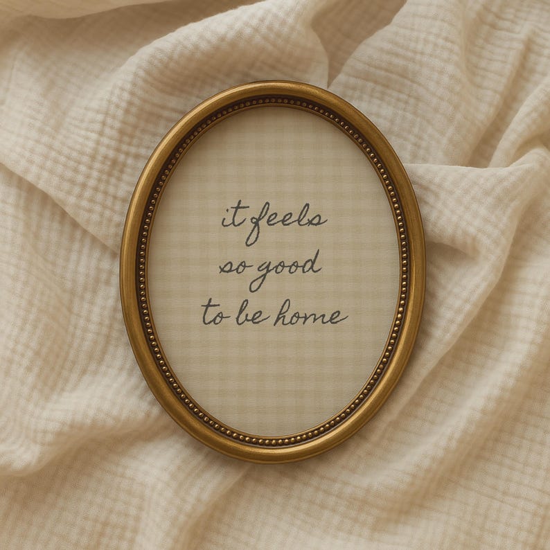 it feels so good to be home quote in hand drawn script typography on neutral beige gingham background in a vintage oval frame.
