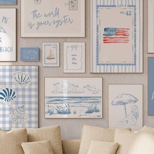 May include: A collection of framed art prints with a beach theme. The prints feature illustrations of seashells, beach scenes, and text like "Meet Me at the Beach" and "The world is your oyster." The color palette is primarily blue and white.