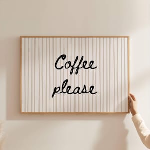 May include: A rectangular framed wall art piece with the words "Coffee please" in black script. The background features vertical beige and white stripes. The frame is made of light brown wood.