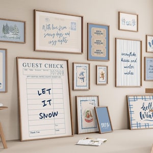 Könnte beinhalten: Eine Sammlung gerahmter Kunstwerke zum Thema Winter mit Holzrahmen. Die Kunstwerke enthalten Sätze wie "Let it Snow" und "Hello Winter" sowie Bilder von Schneeflocken, Schneemännern und Winterlandschaften. Die Farbpalette ist überwiegend blau und weiß.