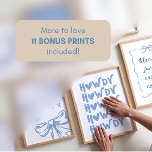 May include: Several framed art prints with light wood frames are displayed on a white wall. One print says "HOWDY" in blue letters with blue hearts. Another print has a bow design. The text "More to love 11 BONUS PRINTS included!" is also visible.