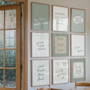 K&ouml;nnte beinhalten: Eine Sammlung von gerahmten Wandbildern mit verschiedenen Textdesigns. Die Kunstwerke zeigen S&auml;tze wie "hey there sweet cheeks", "Best seat in the house" und "Wash your hands". Die Rahmen haben eine nat&uuml;rliche Holzoptik.