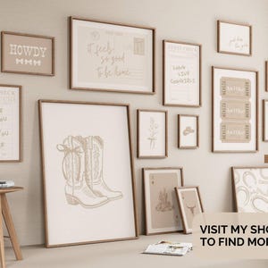 May include: A display of framed wall art with a rustic, country theme. The art features prints with text such as "HOWDY" and "It feels so good to be home," alongside drawings of cowboy boots and other Western motifs. The colour palette is neutral, with beige and brown tones.