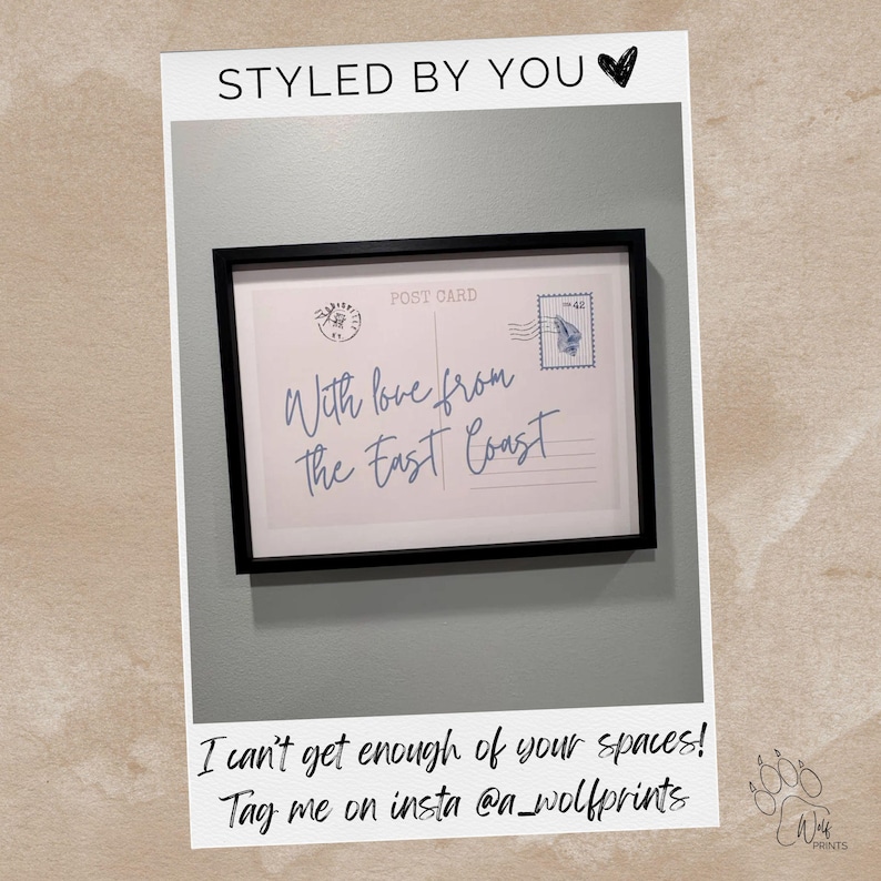 May include: A framed print featuring a vintage postcard design with the text "With love from The East Coast." The print includes a postage stamp and the words "Post Card." The frame is black, and the background is a light gray.