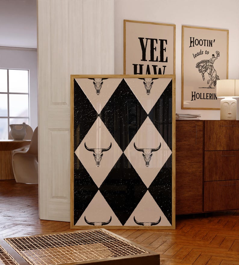 May include: A framed print with a black and white checkered pattern featuring a repeated design of a bull skull. The print is framed in a natural wood frame.