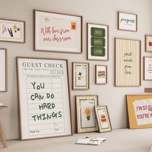 May include: A gallery wall of framed prints with motivational quotes and school-related imagery. The prints display phrases such as "You can do hard things" and "I'm so glad you're here." The frames are a warm brown colour.