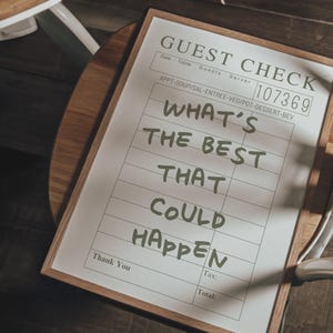 May include: A guest check with the text "WHAT'S THE BEST THAT COULD HAPPEN" in a wooden frame. The check has a serial number and lines for appetizers, soup, salad, entree, vegetables, dessert, and beverages.