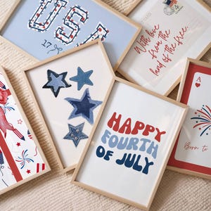 Puede incluir: Una colecci&oacute;n de impresiones art&iacute;sticas enmarcadas con tem&aacute;tica patri&oacute;tica. Las impresiones presentan texto como "USA" y "Happy Fourth of July" en rojo y azul. Algunas impresiones muestran dise&ntilde;os de estrellas y fuegos artificiales, todo en marcos de madera.