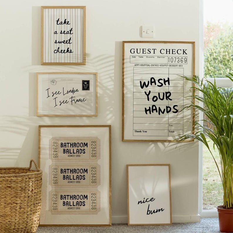 May include: A collection of framed wall art with various text designs. One frame reads "take a seat sweet cheeks", another says "I see London I see France", and a third says "Wash Your Hands". Other frames include "Bathroom Ballads" and "nice bum".