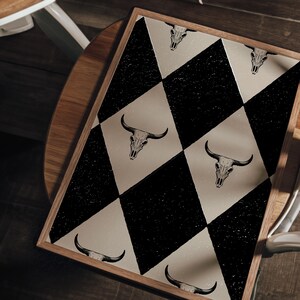 May include: A black and white checkered rug with a cow skull design. The rug has a distressed look and is made of a soft, durable material.