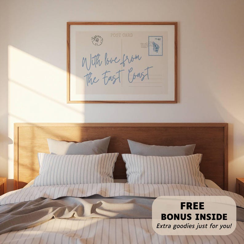 May include: A framed postcard print with the text "With love from The East Coast" in light blue script. The print hangs above a bed with striped pillows and a gray blanket. A bonus offer is visible at the bottom.