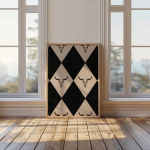May include: A black and white diamond pattern with a bull skull graphic repeated throughout. The pattern is on a canvas print with a wooden frame.