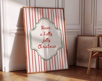 May include: A framed Christmas print with a red and white striped background. The print features the text "Have a holly jolly Christmas" in a decorative font, framed by a green border. The frame is a warm brown colour.
