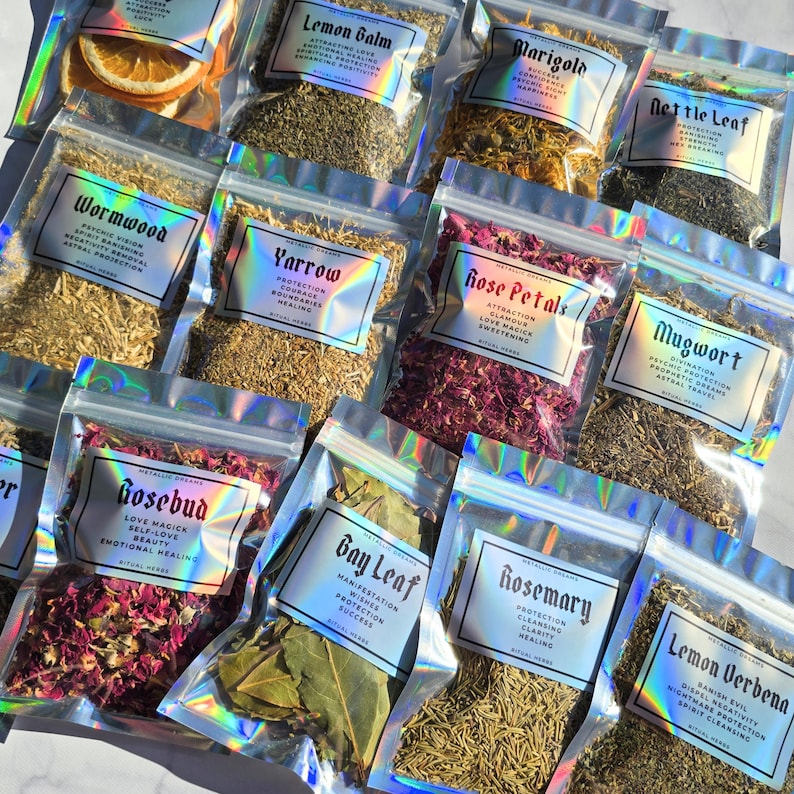 May include: A collection of dried herbs in clear, holographic zip-lock bags. Each bag is labelled with the herb's name and properties, such as "Lemon Balm" and "Rose Petals". The herbs vary in colour and texture, including dried orange slices.