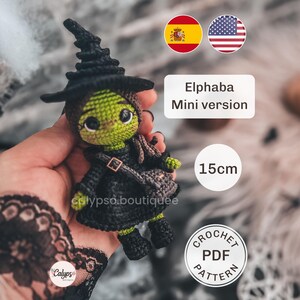 May include: A small green-skinned witch doll made of crocheted yarn, wearing a black pointed hat, black dress, and a small crossbody bag. The doll features large dark eyes and stands 15cm tall. Text on the image reads Elphaba Mini version.