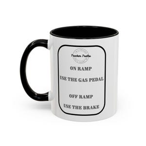 Peut inclure: Une tasse à café en céramique blanche avec une poignée noire et un bord noir. La tasse a un cercle noir avec le texte "Trucker Truths" et le texte "On Ramp Use The Gas Pedal Off Ramp Use The Brake".