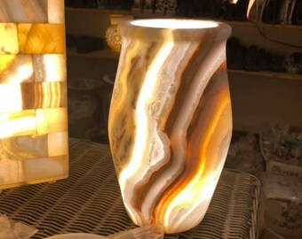 A vase of natural marble that emits light and uses a luminous cappure.