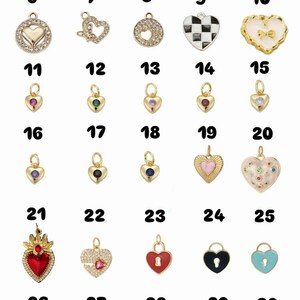 May include: A selection of 30 heart-shaped charms in gold, silver, and enamel. Designs include lockets, gemstones, and patterned surfaces. Each charm has a loop for attaching to jewellery.
