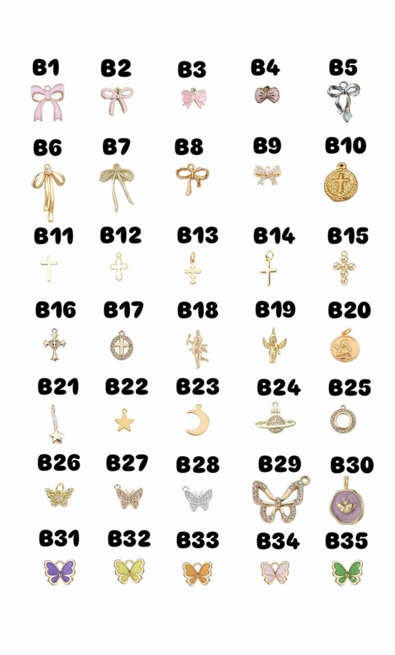May include: A selection of small, decorative charms in various shapes, including bows, crosses, stars, moons, butterflies, and a planet. The charms are gold-toned and some are embellished with crystals or coloured enamel.