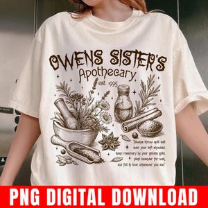 May include: A cream-colored t-shirt featuring a brown graphic print with the text "Owens Sister's Apothecary est. 1995". The design includes illustrations of a mortar and pestle, a glass jar, cinnamon sticks, herbs, and a bowl of salt.