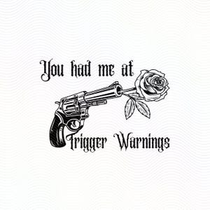 Puede incluir: Gráfico en blanco y negro que presenta un revólver con una rosa en el cañón. El texto dice "You had me at Trigger Warnings" en una fuente gótica. La imagen está sobre un fondo blanco.