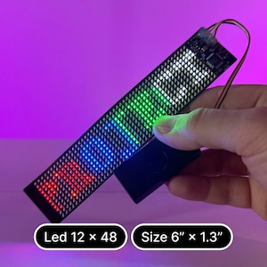 以下が含まれることがあります： 12 x 48 の LED が付いた黒と銀の LED ストリップで、虹色の光を放っています。ストリップの長さは 15.24 cm、幅は 3.3 cm です。画像には「Led 12 x 48」と「Size 6" x 1.3"」と印刷されています。