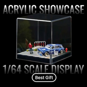 May include: Clear acrylic display case showcasing a blue 1/64 scale model car with a miniature figure and street scene. The text "ACRYLIC SHOWCASE" and "1/64 SCALE DISPLAY" are displayed. The words "Best Gift" are also visible.