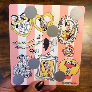 K&ouml;nnte beinhalten: Eine rosa-wei&szlig; gestreifte Karte mit Illustrationen von Cruella de Vil und Dalmatinerhunden. Die Karte enth&auml;lt den Text "Fabulous & Wicked" und mehrere Rubbelkreise. Das Design beinhaltet Schleifen, Herzen und gerahmte Portr&auml;ts.