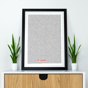 Könnte beinhalten: Ein schwarzer gerahmter Druck mit weißem Hintergrund und einem grauen Textmuster. Der Text ist eine einzelne Zeile am unteren Rand des Drucks, die "Ich bin Iron Man" lautet.