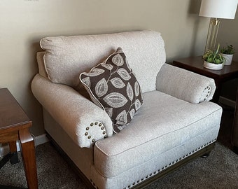 Accent pillow and nailhead trim on a modern farmhouse chair and a half in beige