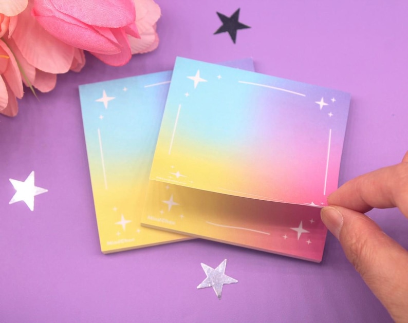 Colorful dreamy sticky notes featuring a vibrant pastel background with a subtle star border, placed on a purple surface with decorative flowers and stars.