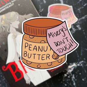 May include: A sticker of a peanut butter jar with the text "Misery's Don't Touch!" on a pink sticky note.