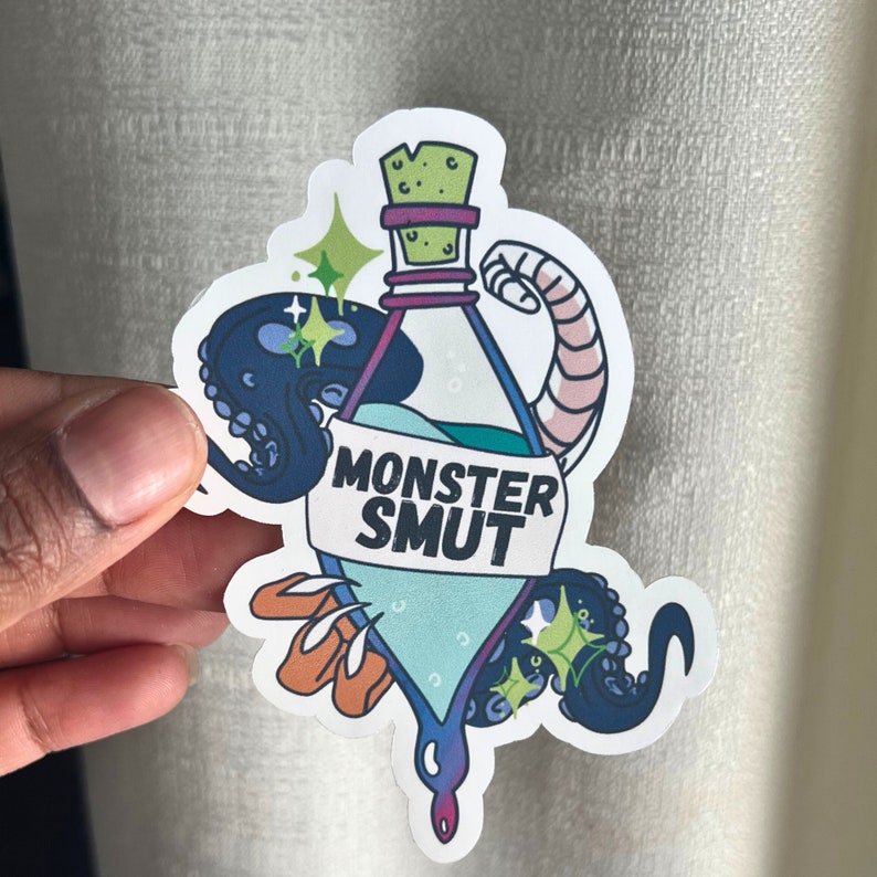 May include: A sticker featuring a blue and green potion bottle with the text "Monster Smut" on a white banner. The bottle is surrounded by a black octopus with green sparkles.