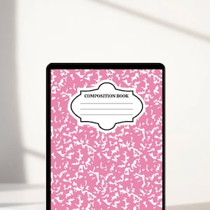 May include: A pink composition book with a black border and the text "COMPOSITION BOOK" in a white oval.