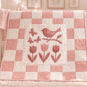 Può includere: Una trapunta patchwork rosa e bianca con un disegno di uccelli, farfalle e tulipani. La trapunta è drappeggiata su una culla bianca, con una coperta abbinata e peluche visibili. Il bordo della trapunta è una corda ritorta.