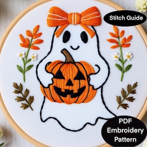 Könnte beinhalten: Gesticktes Halloween-Design mit einem weißen Geist, der einen orangefarbenen Kürbis hält. Der Geist hat schwarze Augen und einen lächelnden Mund, mit einer orangefarbenen Schleife. Das Design enthält orangefarbene und grüne florale Akzente sowie den Text "Stitch Guide" und "PDF Embroidery Pattern".