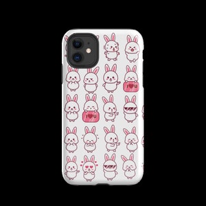 May include: White iPhone case featuring a pattern of adorable pink and white bunnies with various expressions. The bunnies are holding hearts, wearing sunglasses, and displaying different facial expressions.