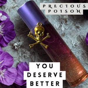 May include: A cylindrical glass roller bottle with a purple cap, containing a gradient liquid transitioning from purple to orange with glitter. A gold-toned skull and crossbones charm is attached. Text reads PRECIOUS POISON and YOU DESERVE BETTER.