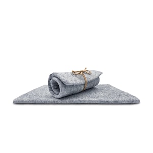 May include: A rectangular light gray felt mat with a textured, mottled surface. A portion of the mat is rolled up and secured in the center with a thin, natural-colored jute twine tied in a simple bow, creating a layered and compact appearance.