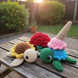 May include: Crocheted turtle toys with unique designs. One is a sunflower, another a red rose, and the third is an ice cream cone. The toys are made of soft yarn and have large, googly eyes. The toys are on a wooden table.