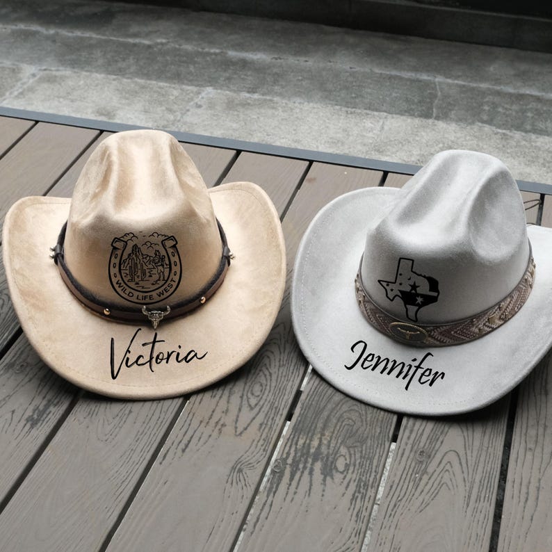 May include: Two cowboy hats. One is tan with a horseshoe and landscape design, the name "Victoria" is printed below. The other is light gray with a Texas outline design, and the name "Jennifer" is printed below.