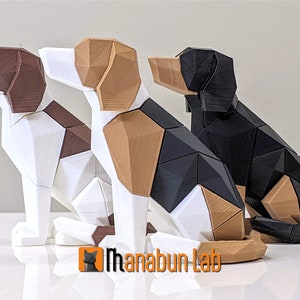 May include: Three geometric dog sculptures in white, brown, black, and tan. The dogs are in a sitting position, with a faceted design. The logo "Manabun Lab" is visible in the bottom left corner. The sculptures are likely made of plastic.