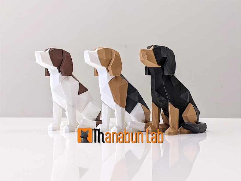 May include: Three geometric dog sculptures in white, brown, black, and tan. The dogs are in a sitting position with their heads tilted upwards. The logo "Ihanabun Lab" is visible in the bottom center.