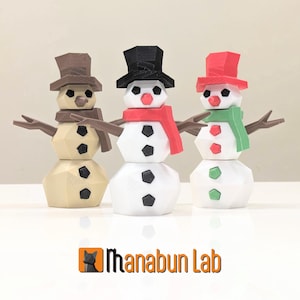 Puede incluir: Tres muñecos de nieve impresos en 3D con sombreros y bufandas de diferentes colores. El muñeco de nieve de la izquierda tiene un sombrero y una bufanda marrones, el muñeco de nieve del centro tiene un sombrero negro y una bufanda roja, y el muñeco de nieve de la derecha tiene un sombrero rojo y una bufanda verde.