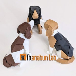May include: Three geometric dog sculptures in brown, black, and white. The dogs are arranged in a circle, with the logo "Ihanabun Lab" visible in the lower right corner. The sculptures have a modern, polygonal design.