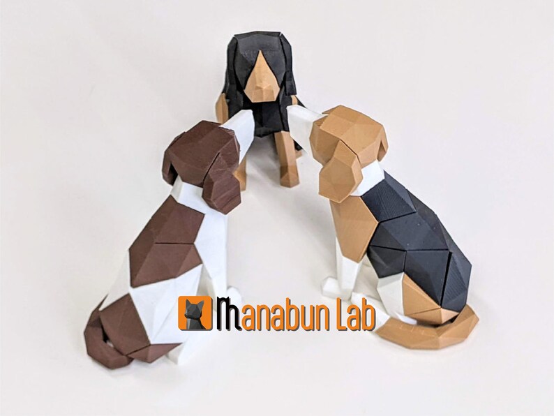 May include: Three geometric dog sculptures in brown, black, and white. The dogs are arranged in a circle, with the logo "Ihanabun Lab" visible in the lower right corner. The sculptures have a modern, polygonal design.