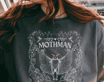 May include: A dark gray sweatshirt with a white graphic design of a moth with the text "Mothman" and "Weird Butterfly" printed on it.