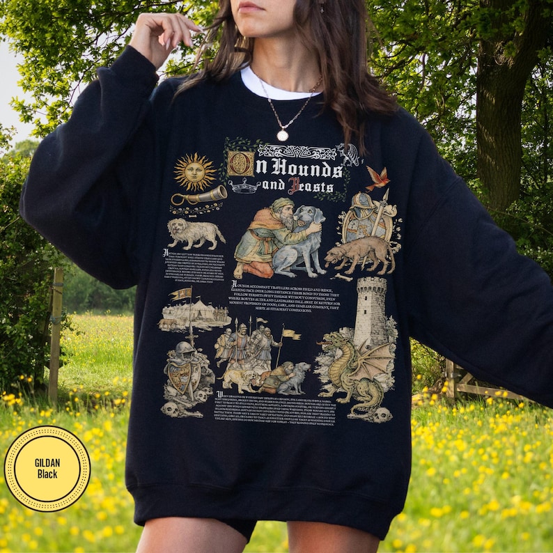 May include: Black sweatshirt with a medieval-themed graphic. The design includes illustrations of dogs, knights, a dragon, and the text "On Hounds and Beasts." The sweatshirt has a white collar and the Gildan Black label.